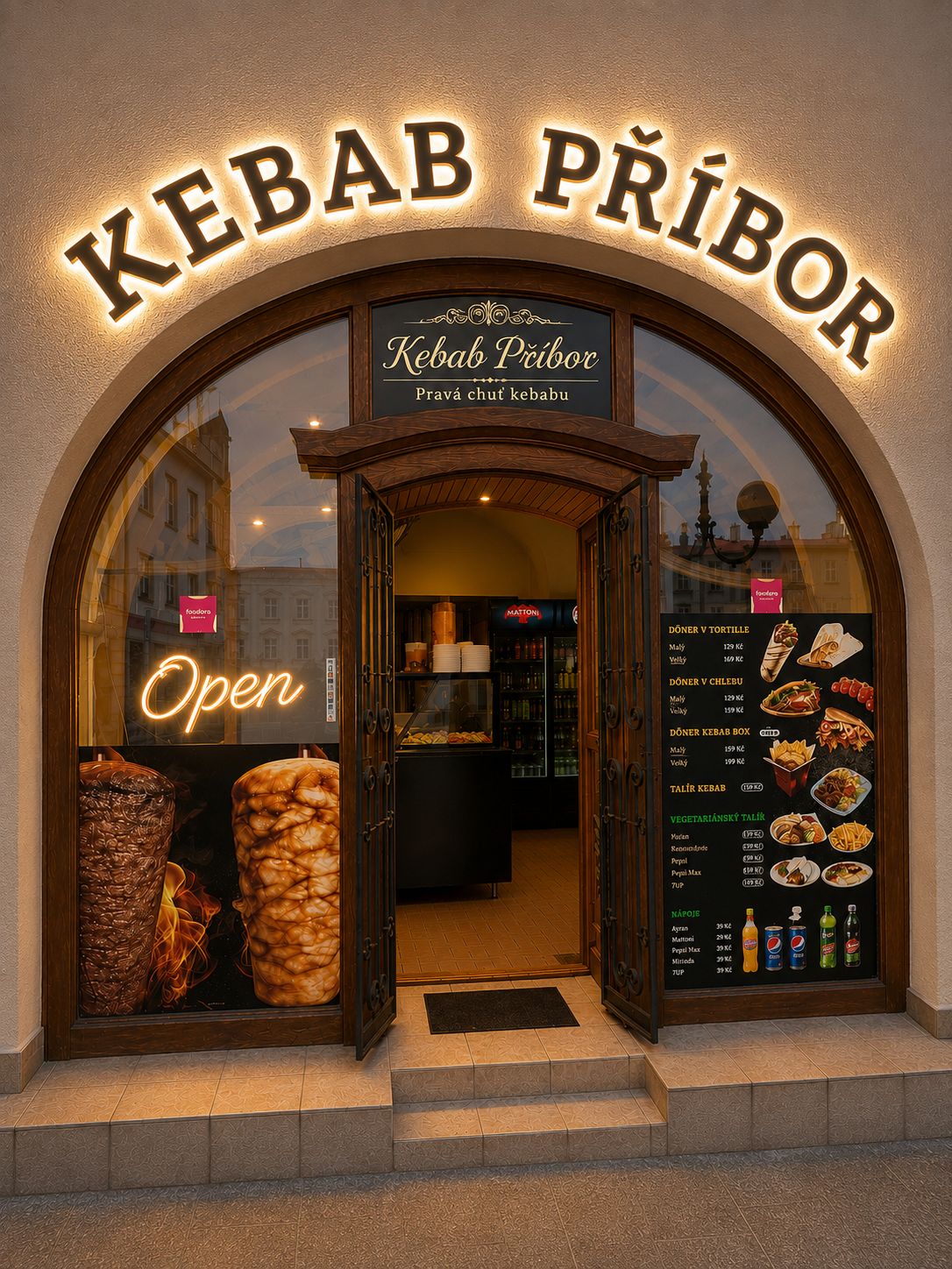 Vchod Kebab Příbor pod kamenným obloukem za soumraku